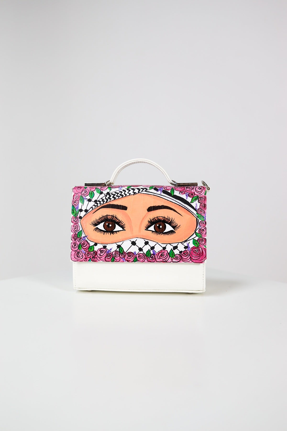 Handbag with a face design and floral accents on a white background