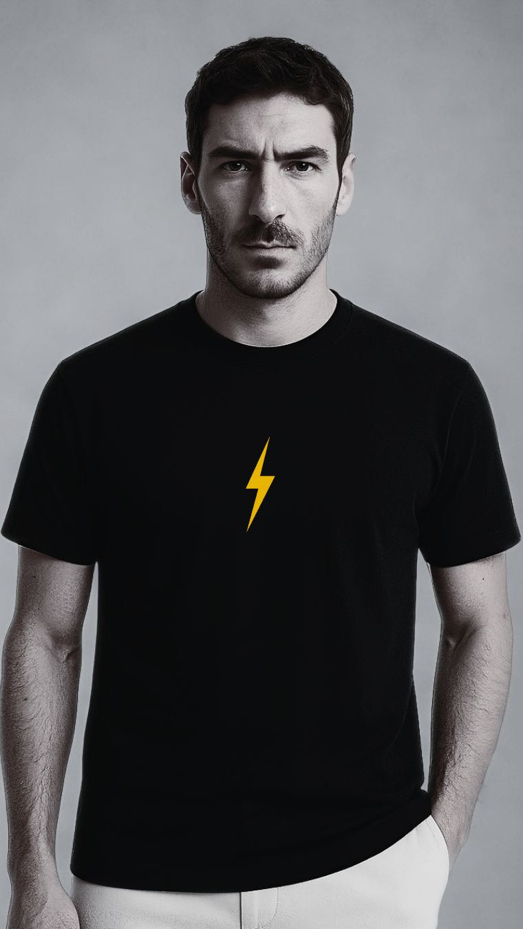 Man wearing a black t-shirt with a yellow lightning bolt on a gray background