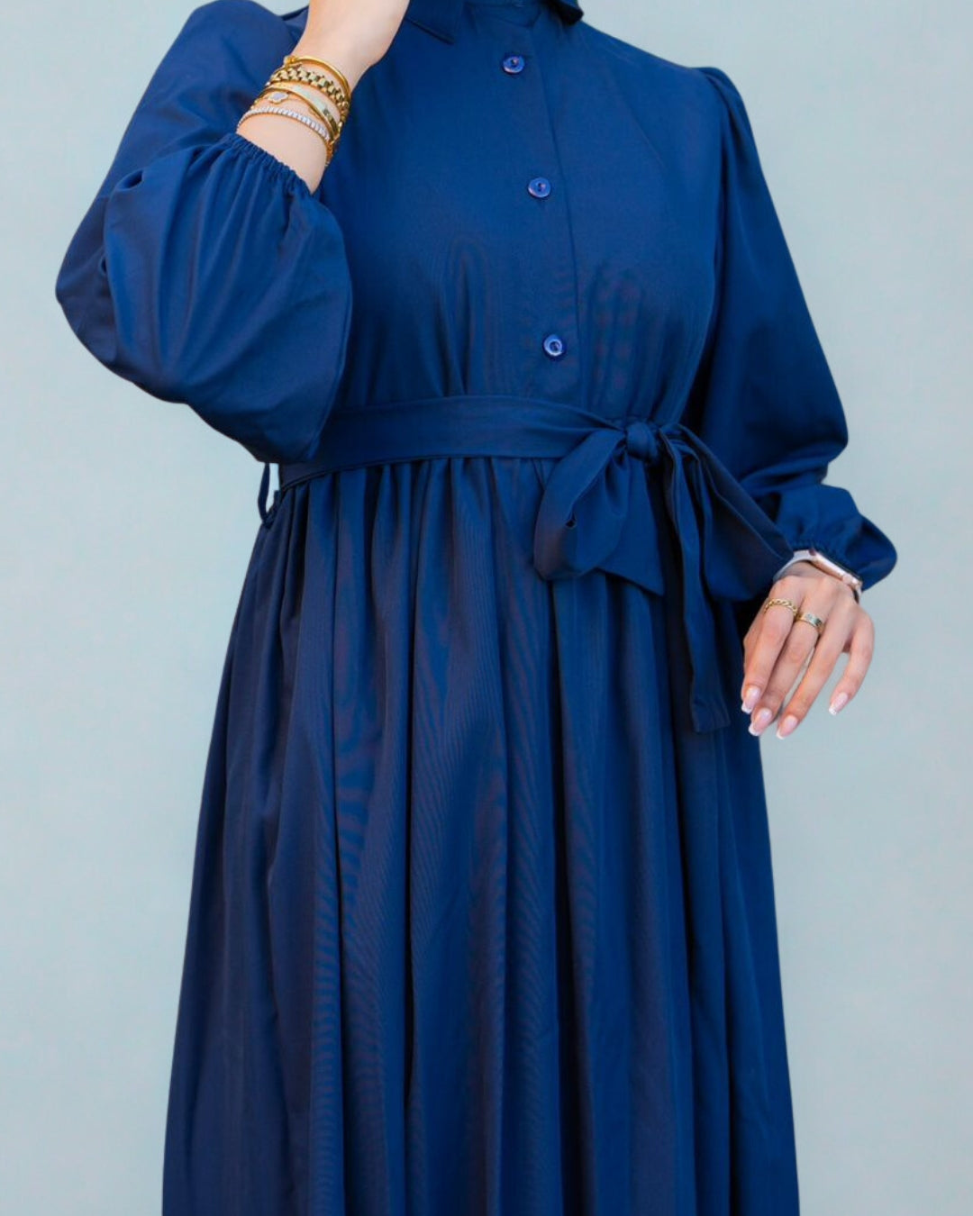 Navy blue dress with a belt on a plain background