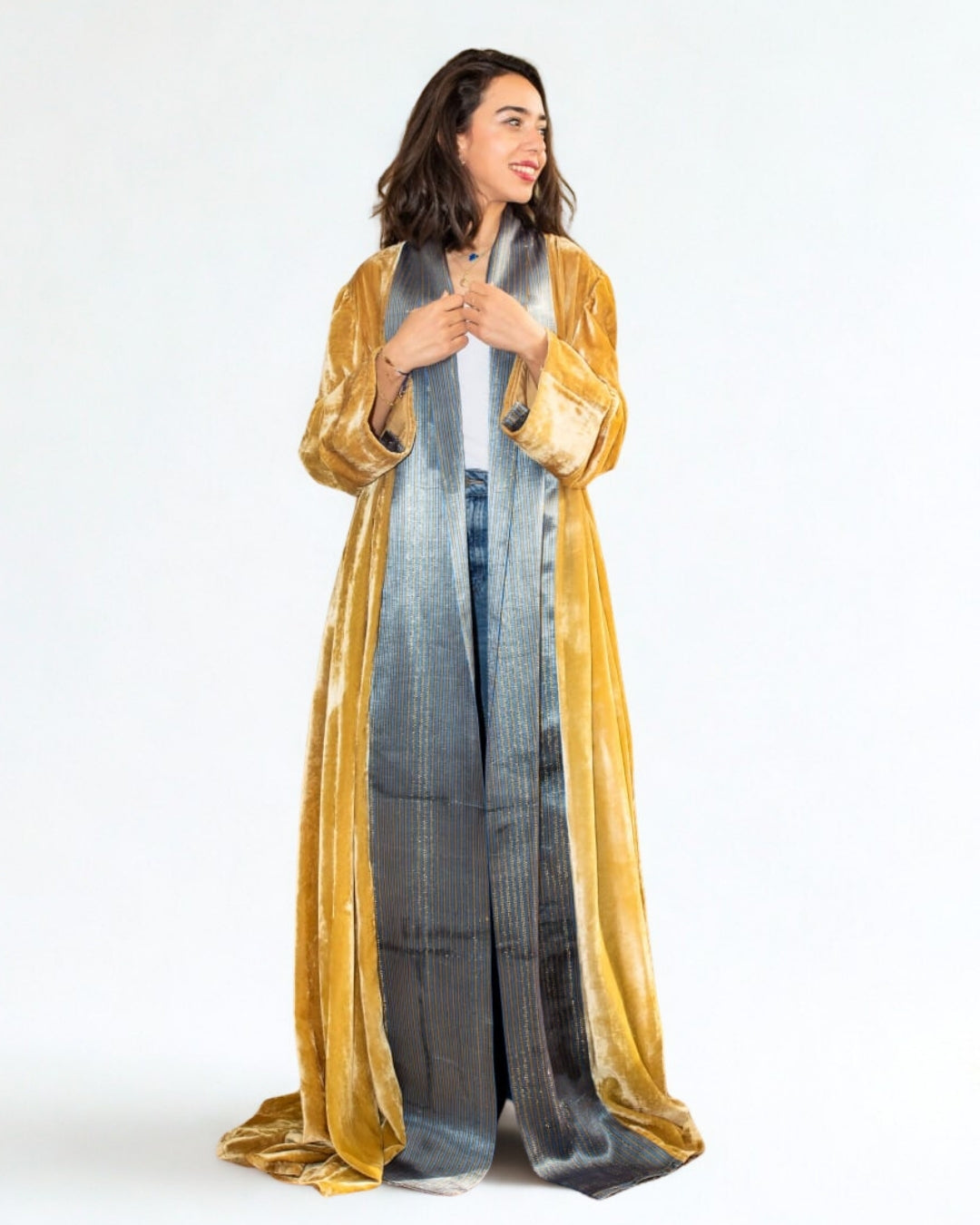 Woman wearing a long, flowing garment with a gradient pattern and gold border.