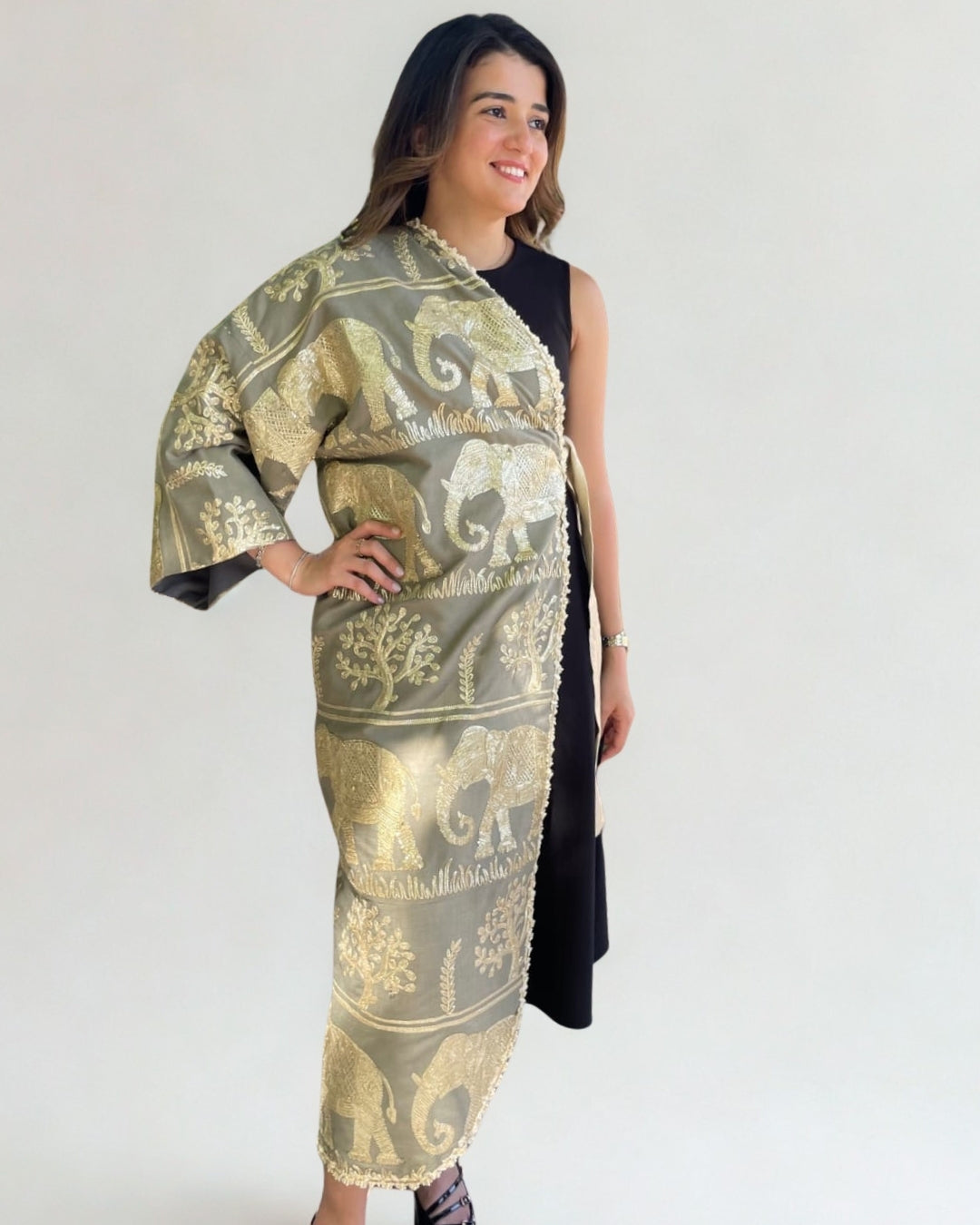 Woman wearing a gold and black patterned scarf on a white background