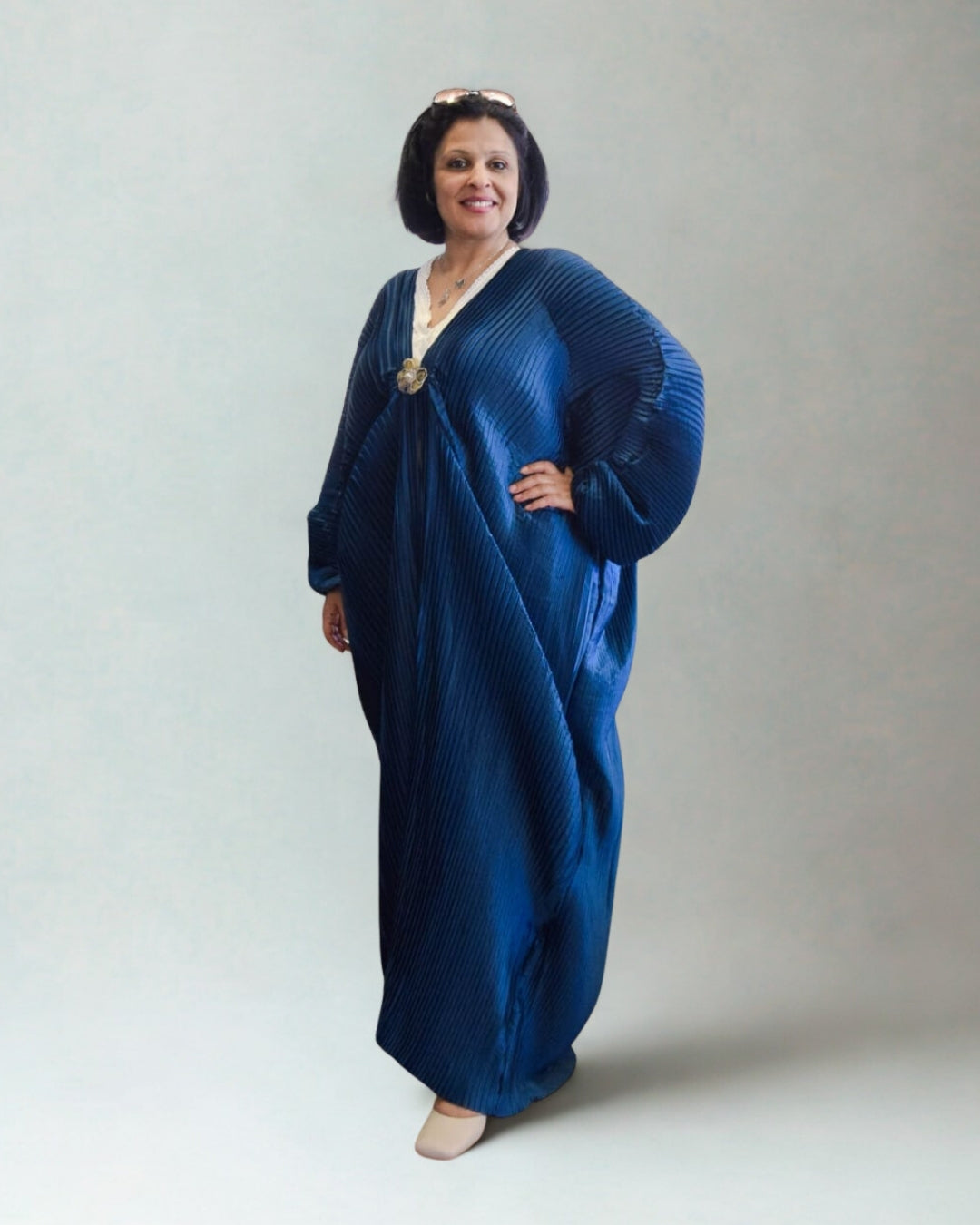 Woman wearing a blue dress against a plain background