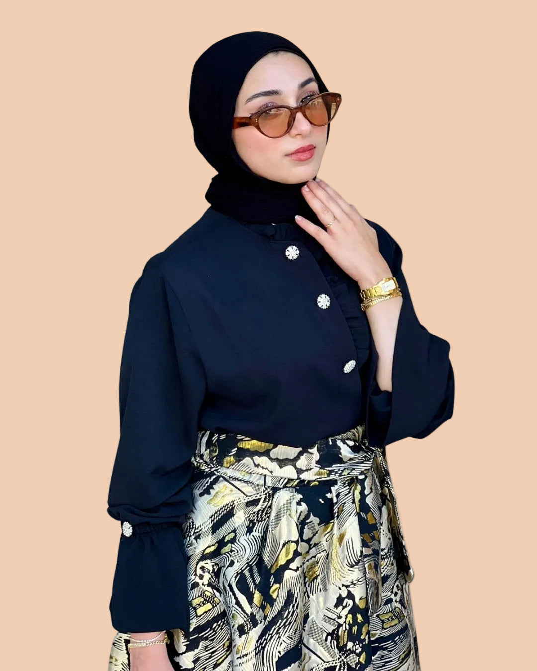 Woman wearing a dark blue blouse with white buttons and a patterned skirt on a white background