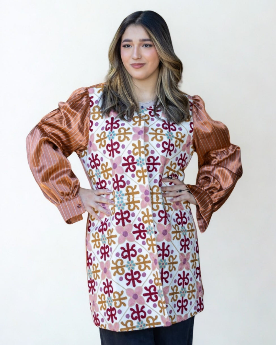 Woman wearing a patterned shirt with brown sleeves on a white background