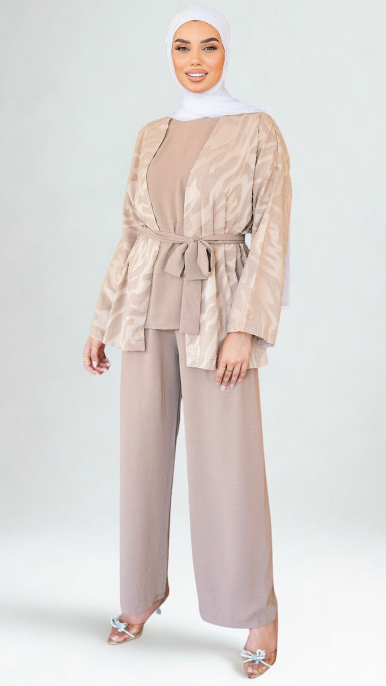 Woman wearing a beige outfit with a matching hijab on a white background