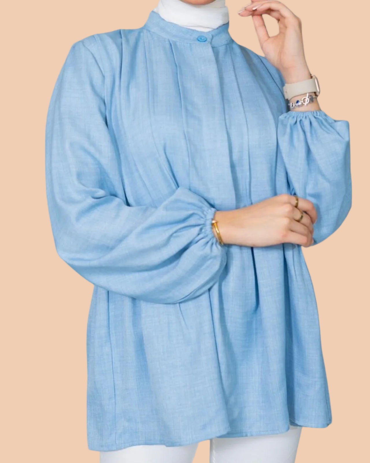 Light blue blouse worn by a person on a light gray background