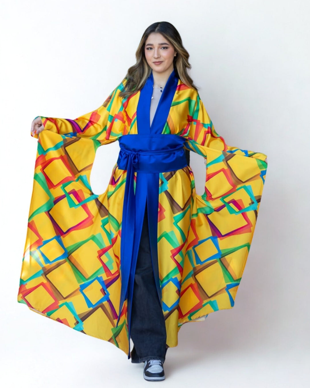 Woman wearing a colorful kimono with a blue belt on a white background
