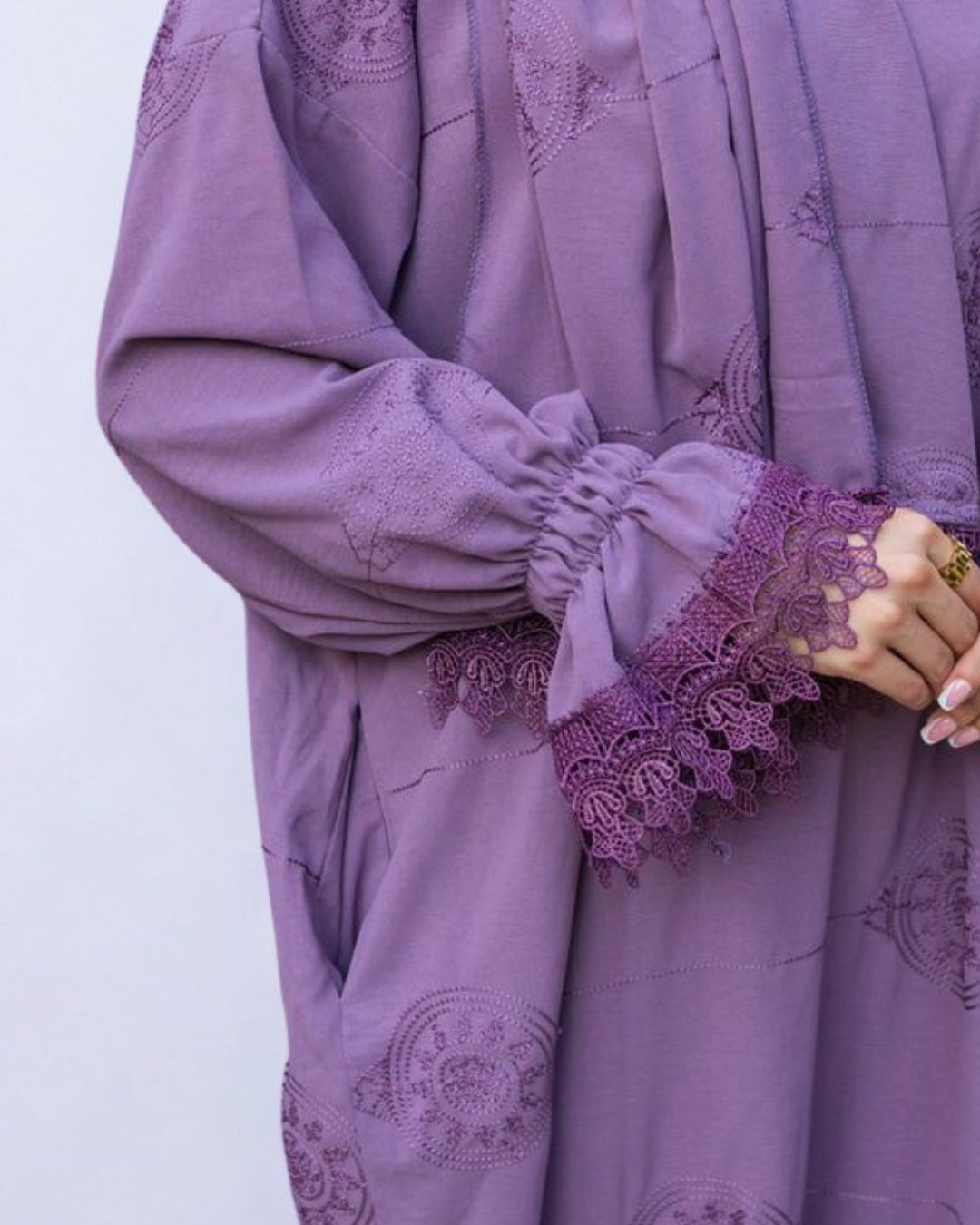 Purple outfit with lace details on a white background