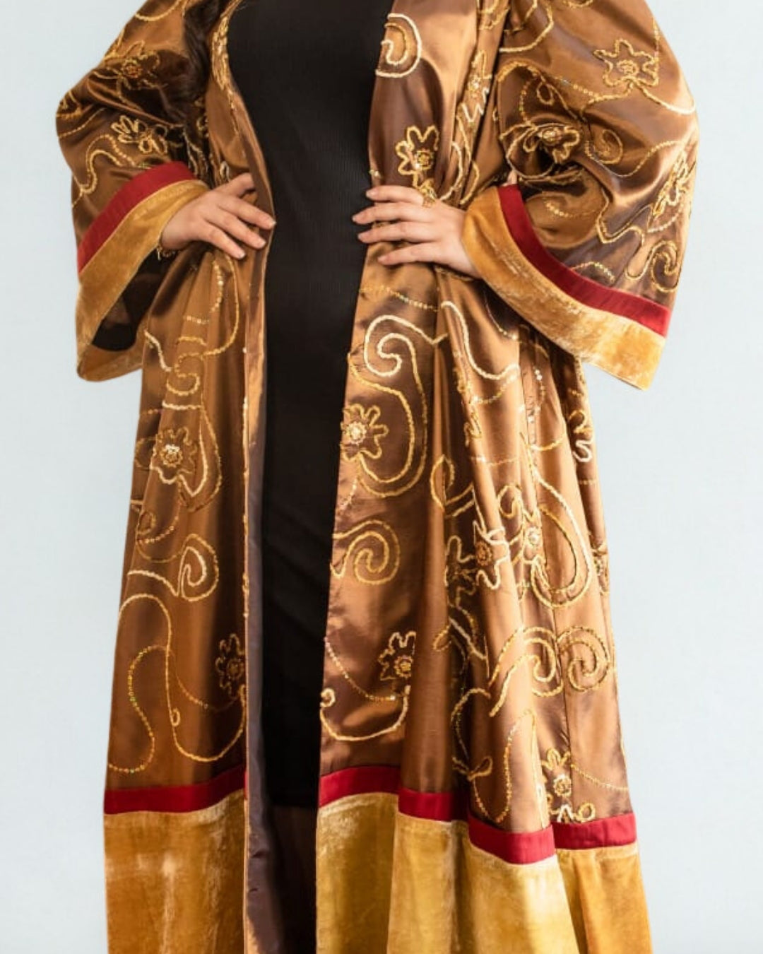 Brown embroidered robe with gold patterns on a plain background