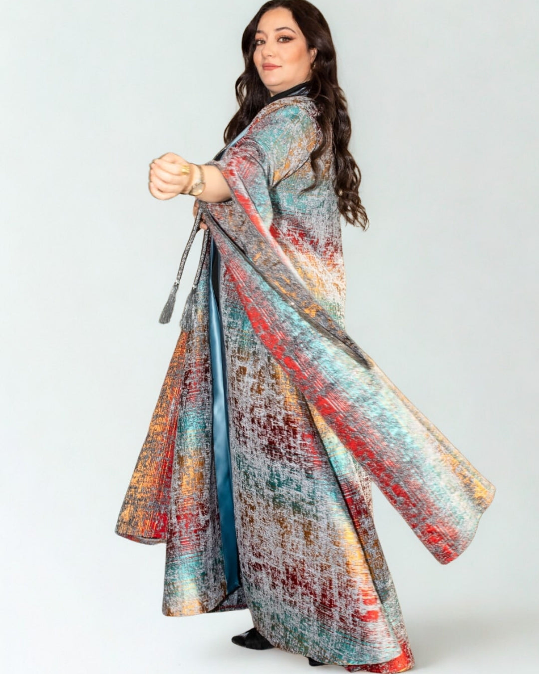 Woman wearing a colorful, patterned dress on a white background
