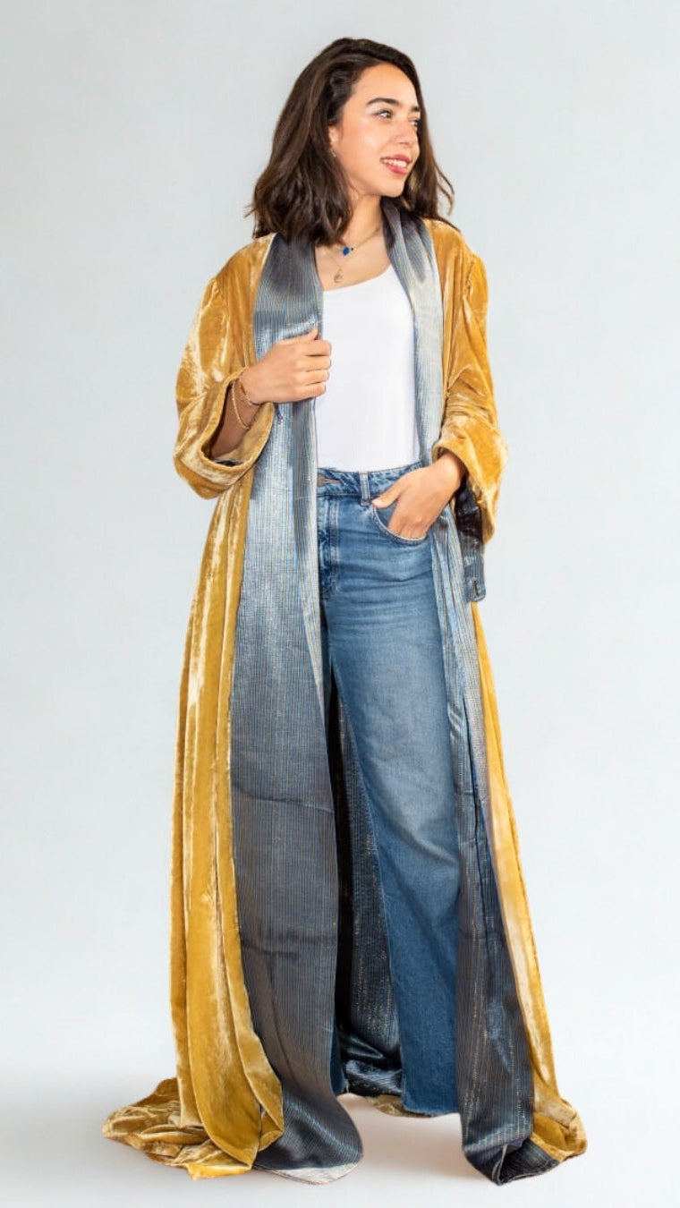 Woman wearing a long, gradient scarf with gold, blue, and gray colors on a white background.