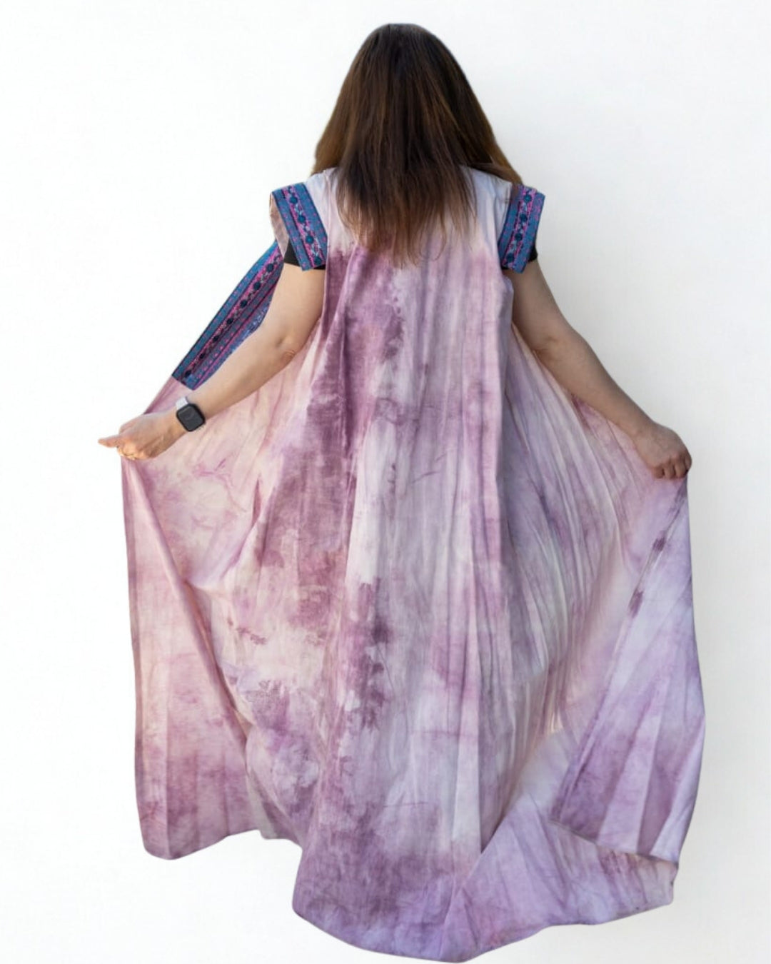 Person wearing a long, flowing dress with a tie-dye pattern on a white background