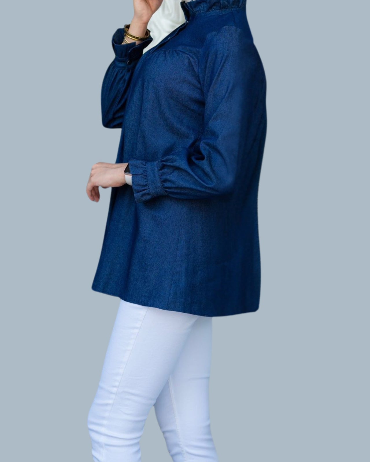 Person wearing a blue jacket and white pants on a gray background