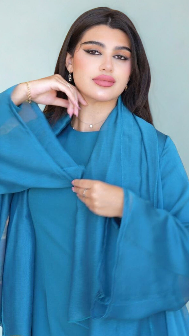 Woman wearing a blue outfit against a plain background