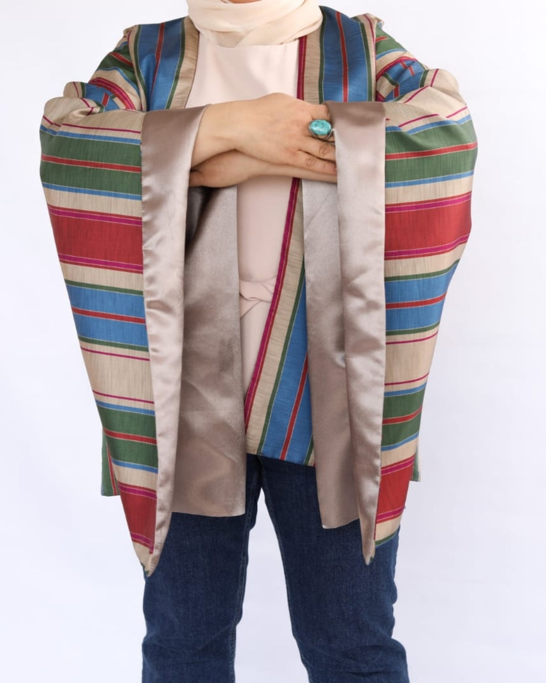 Colorful striped shawl draped over a person on a white background