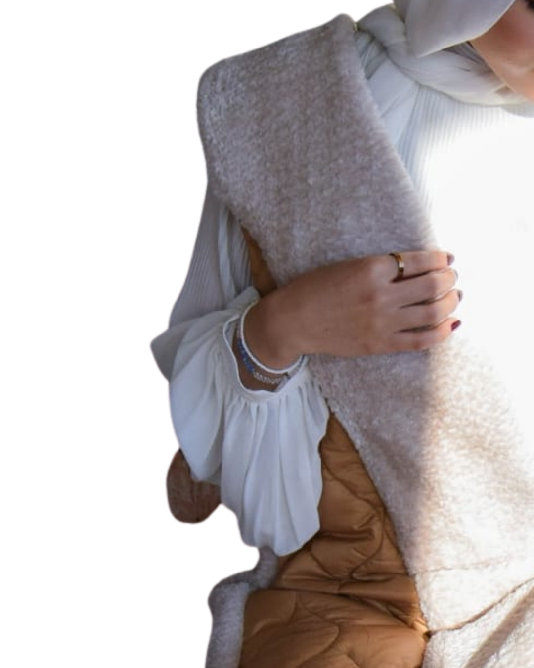 Person wearing a light-colored scarf and holding a brown bag on a white background