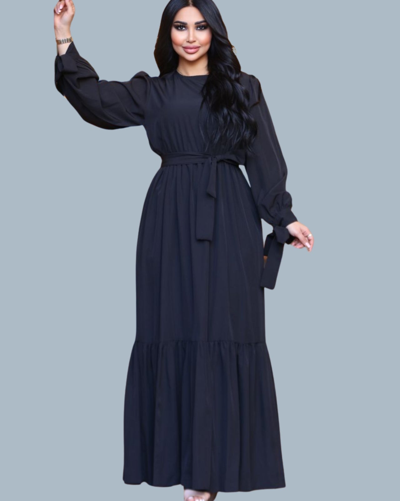 Woman wearing a black long-sleeve dress on a gray background