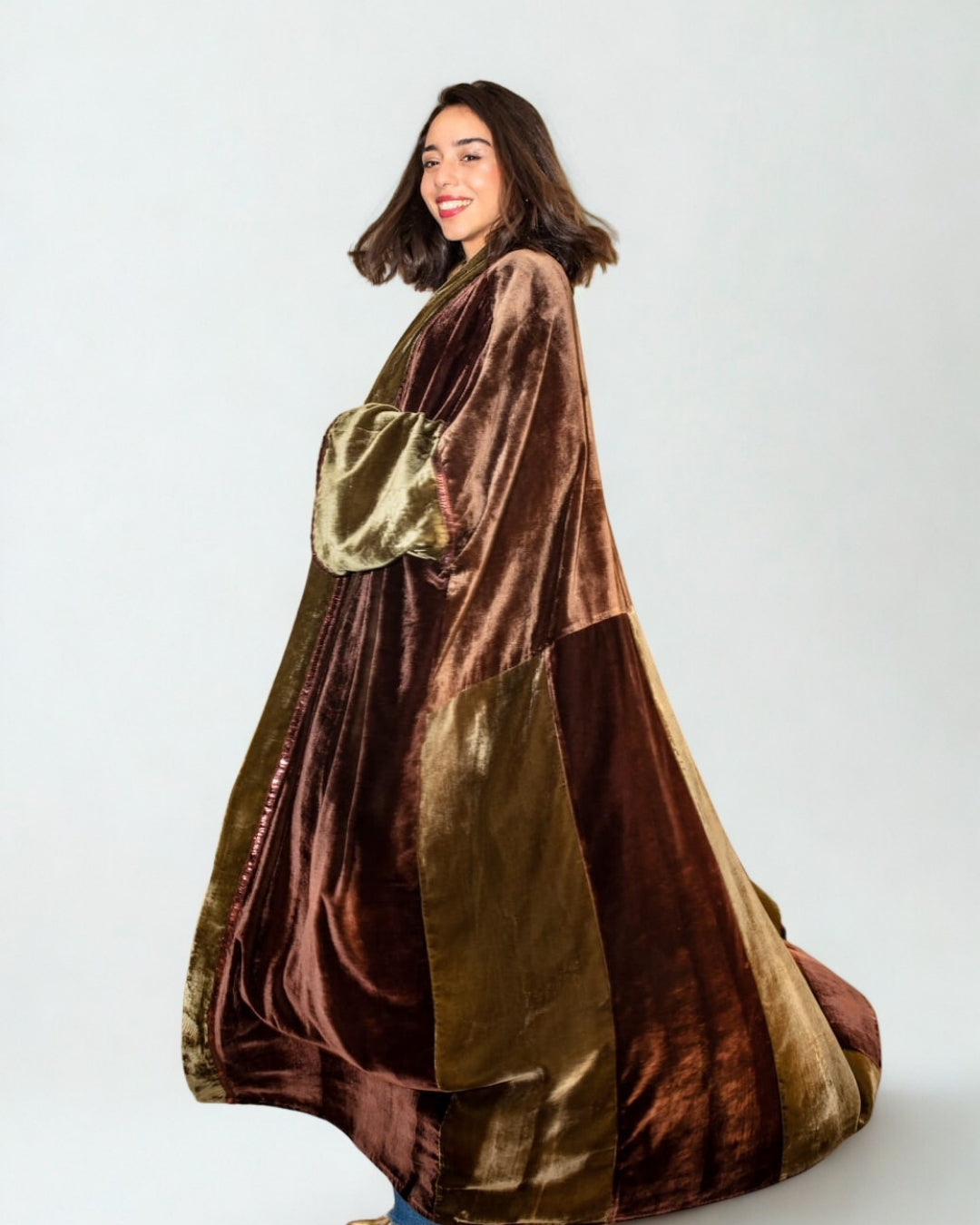 Woman wearing a brown and gold velvet robe against a white background