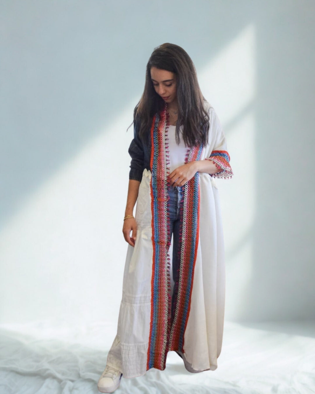 Woman wearing a long, patterned dress with a white background