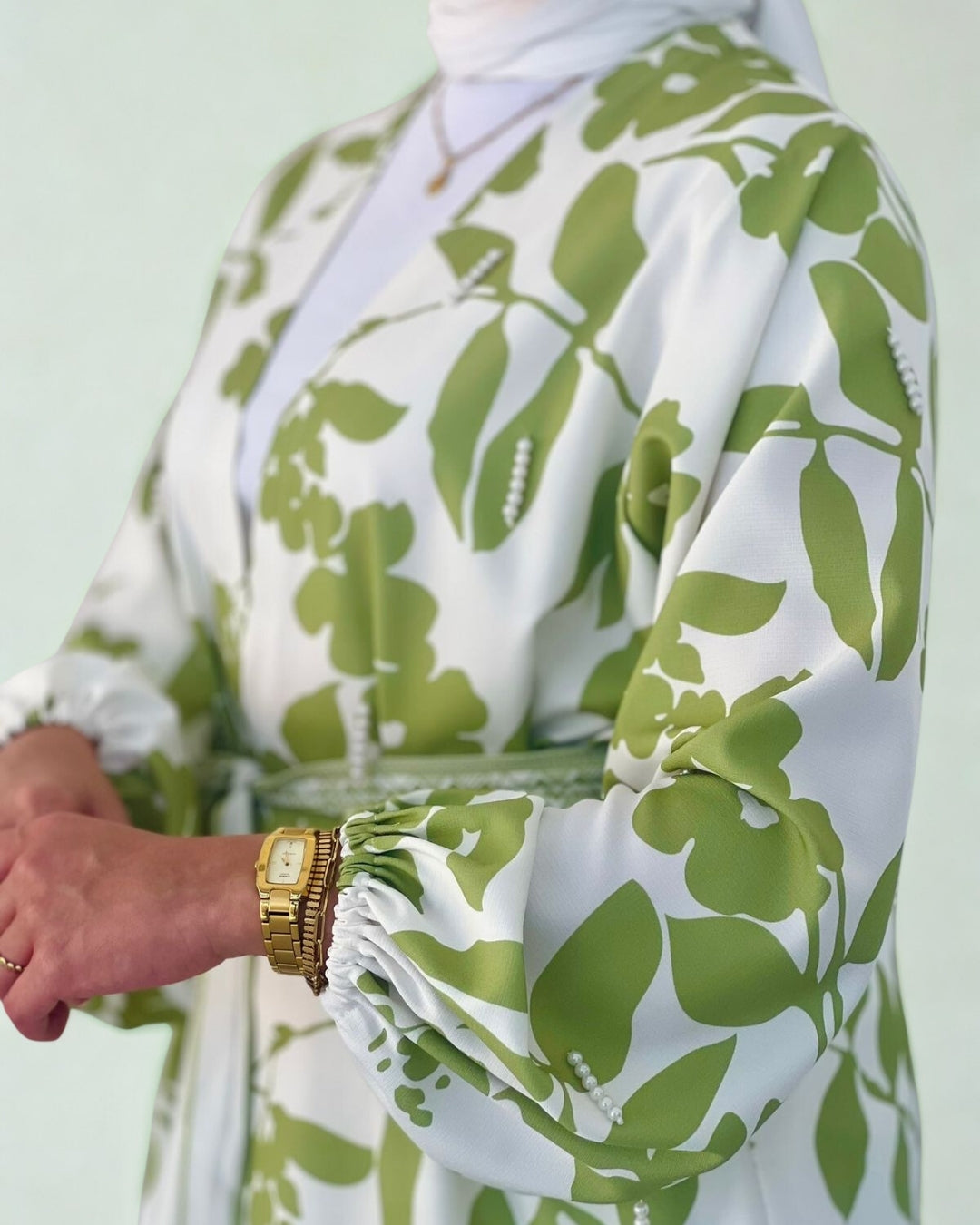 Green and white floral patterned garment on a light green background