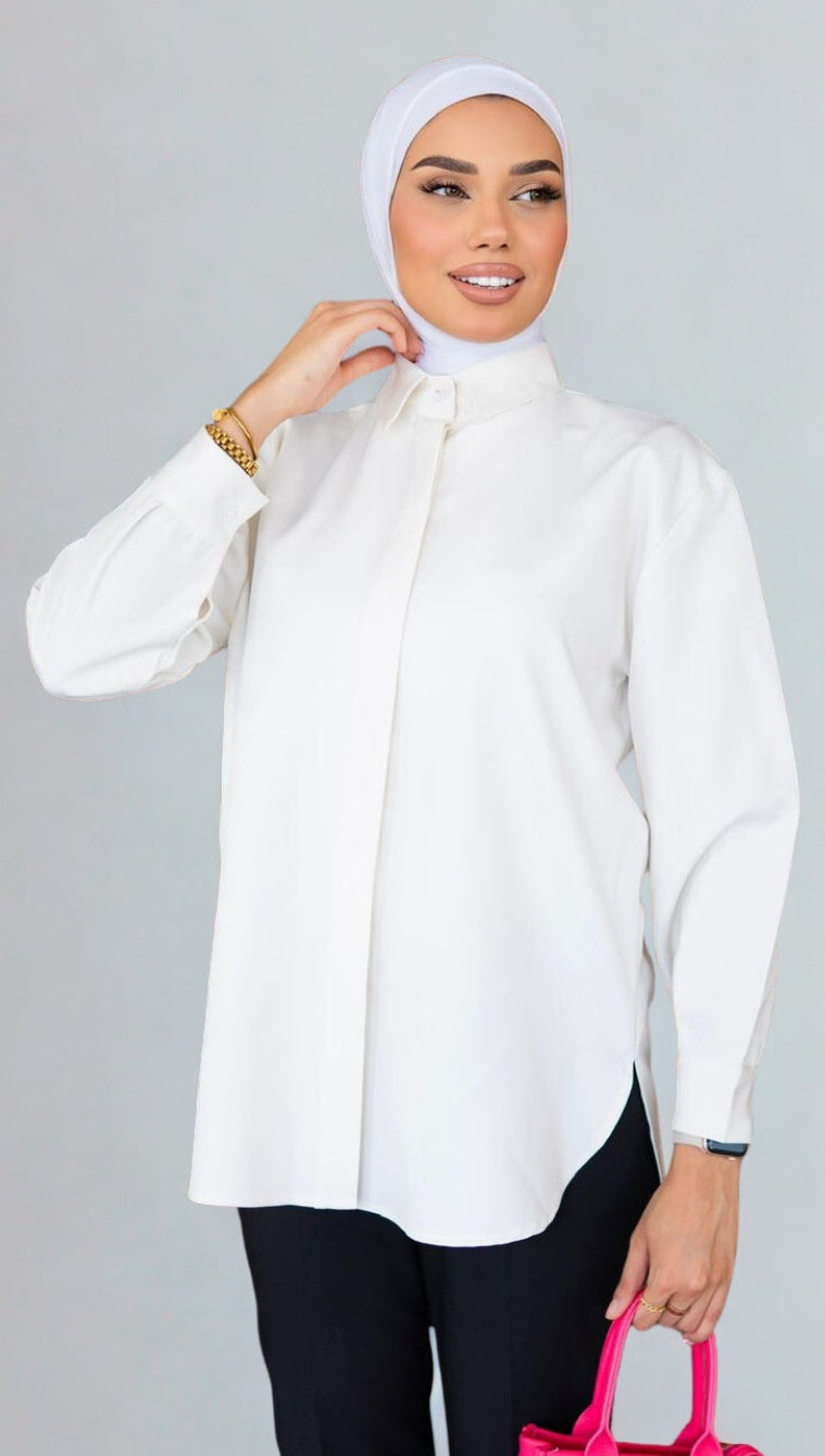 Woman wearing a white blouse and hijab with a pink bag on a gray background