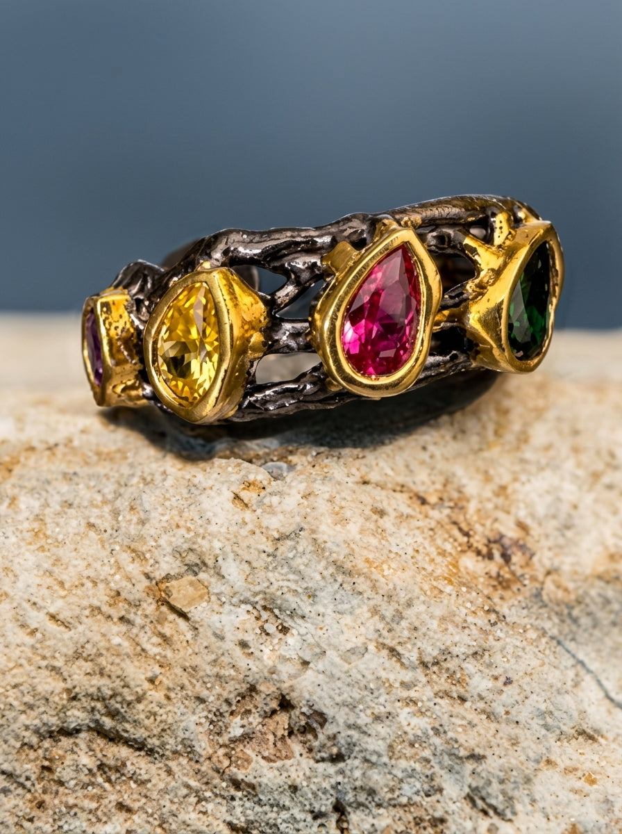 Ring with colorful gemstones on a stone surface