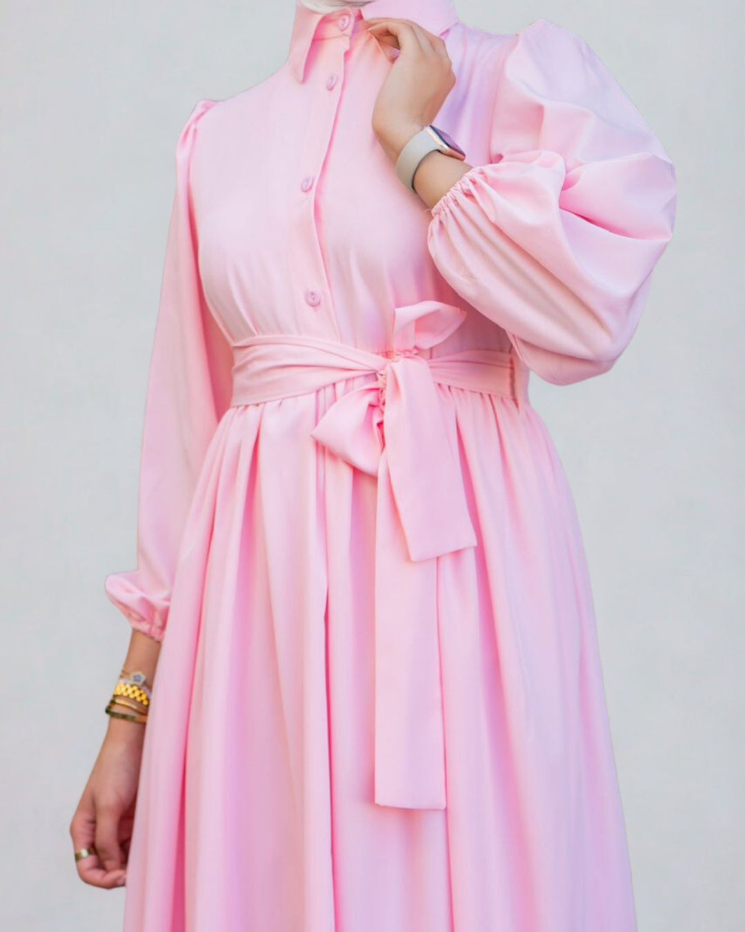 Pink dress with a belt on a plain background