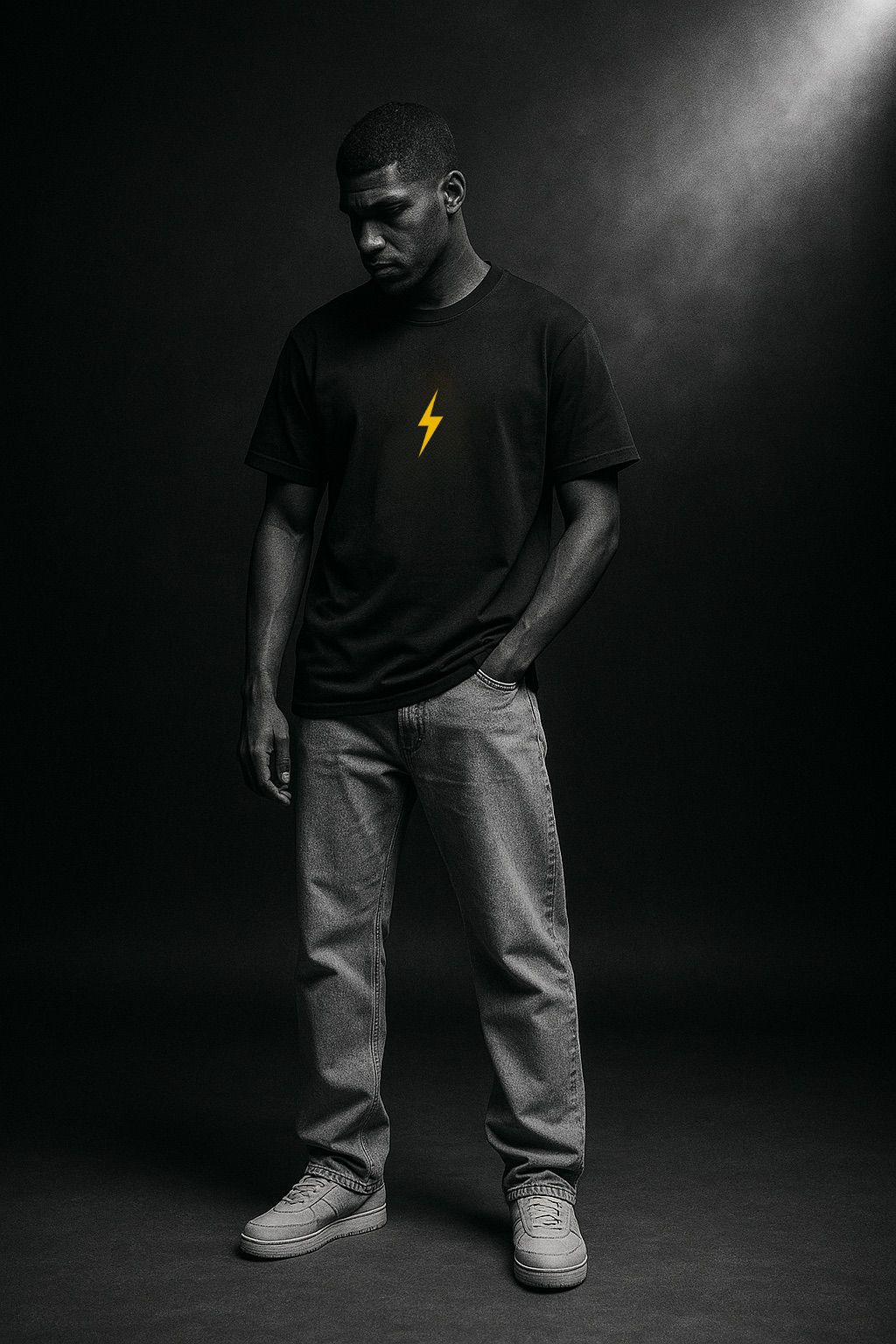 Man wearing a black t-shirt with a yellow bolt design on a dark background