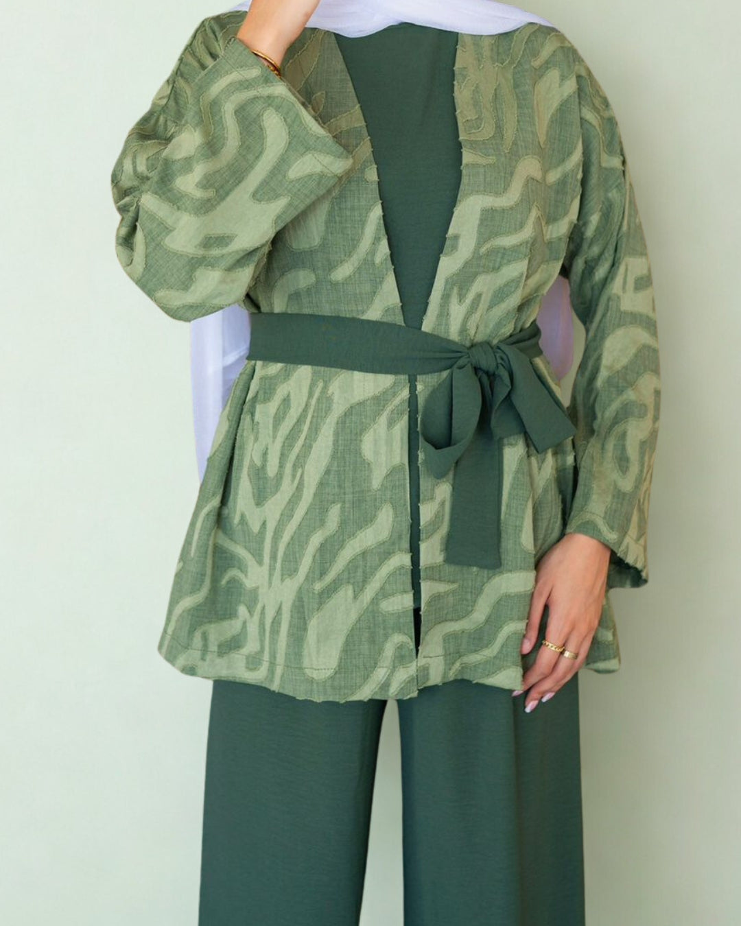 Green patterned jacket with matching pants on a plain background