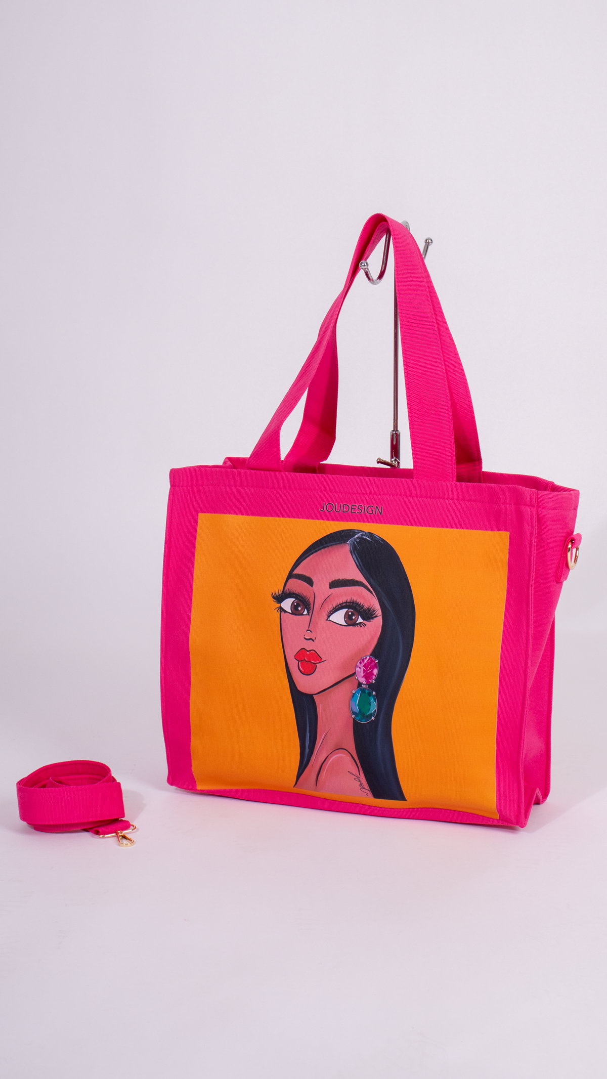 Pink tote bag with character design, pink wallet, and pink flower on a white background