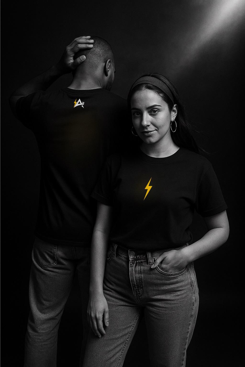 Two people wearing black t-shirts with yellow designs against a dark background