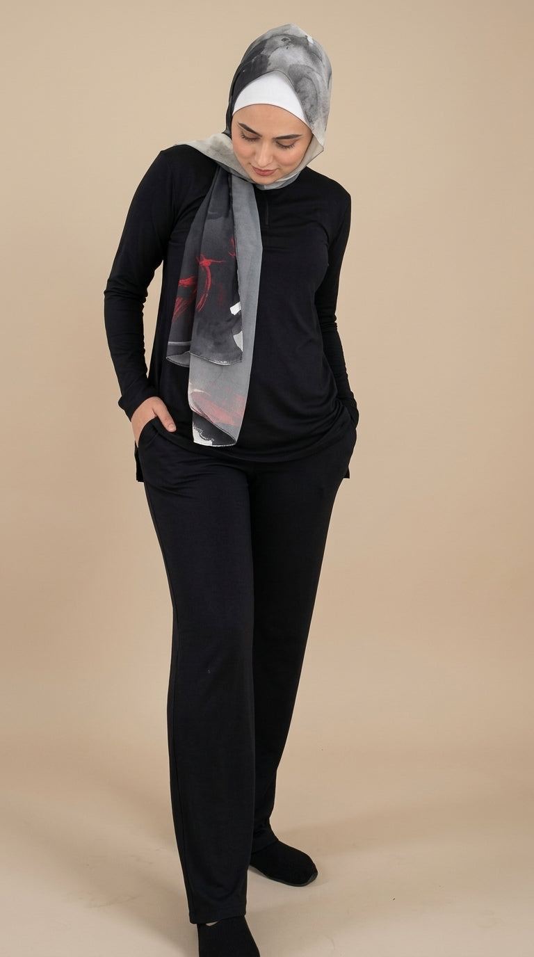 Woman wearing a black outfit with a headscarf on a beige background
