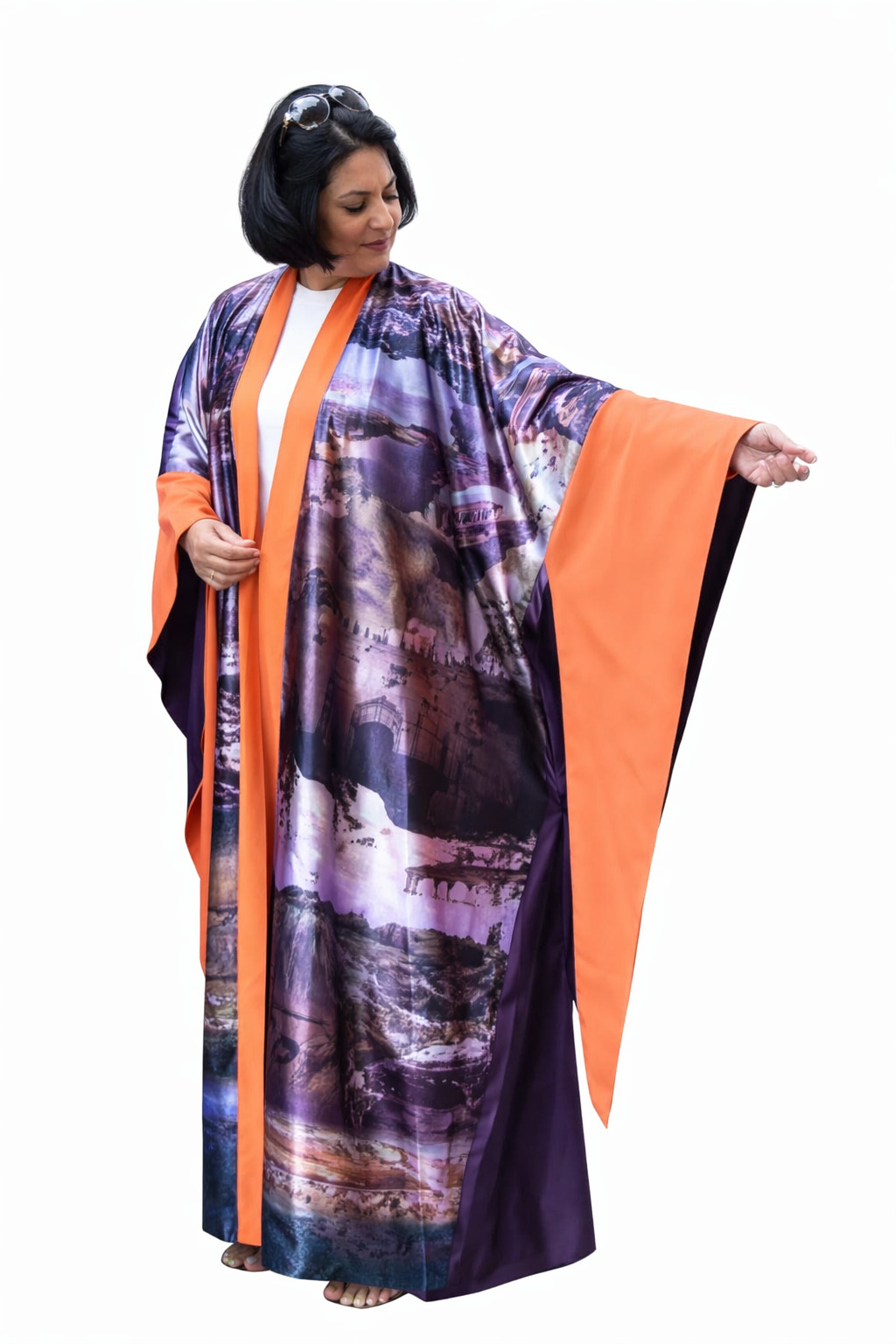 Woman wearing a long, colorful dress with an orange border on a white background