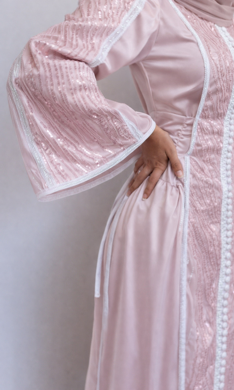 Pink dress with white lace details on a plain background