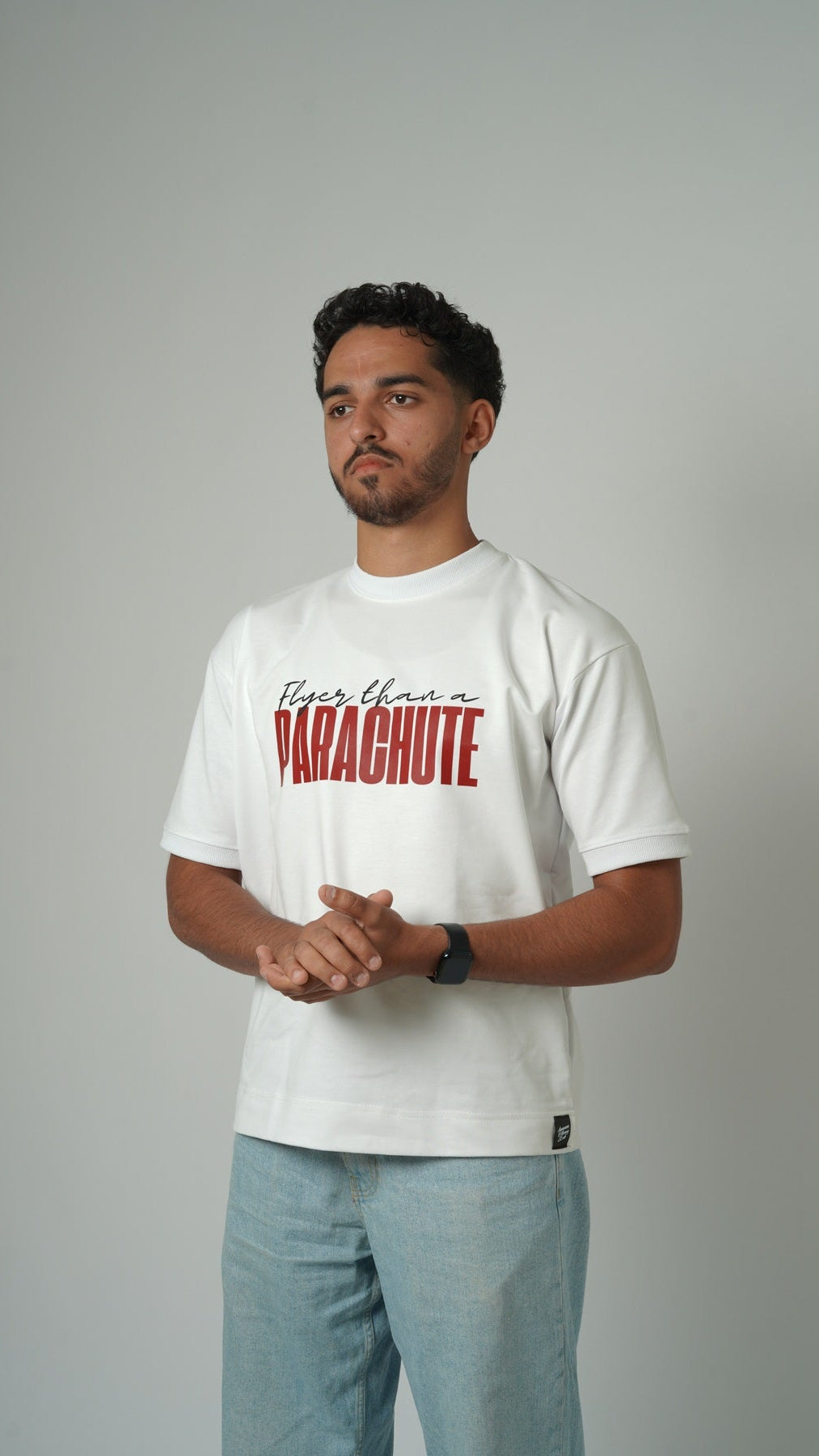 Man wearing a white t-shirt with red text on a gray background