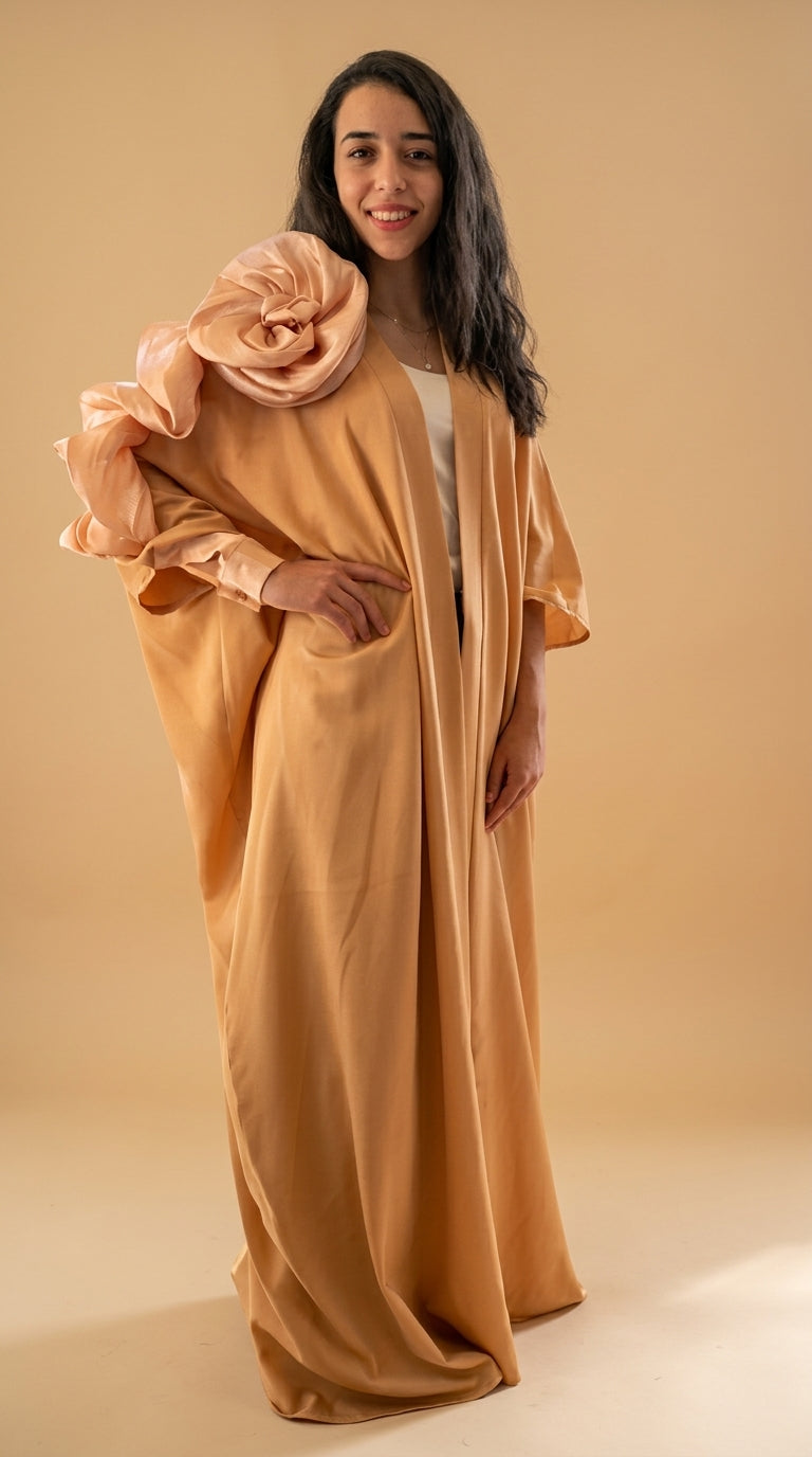Woman wearing a long, flowing beige garment against a beige background