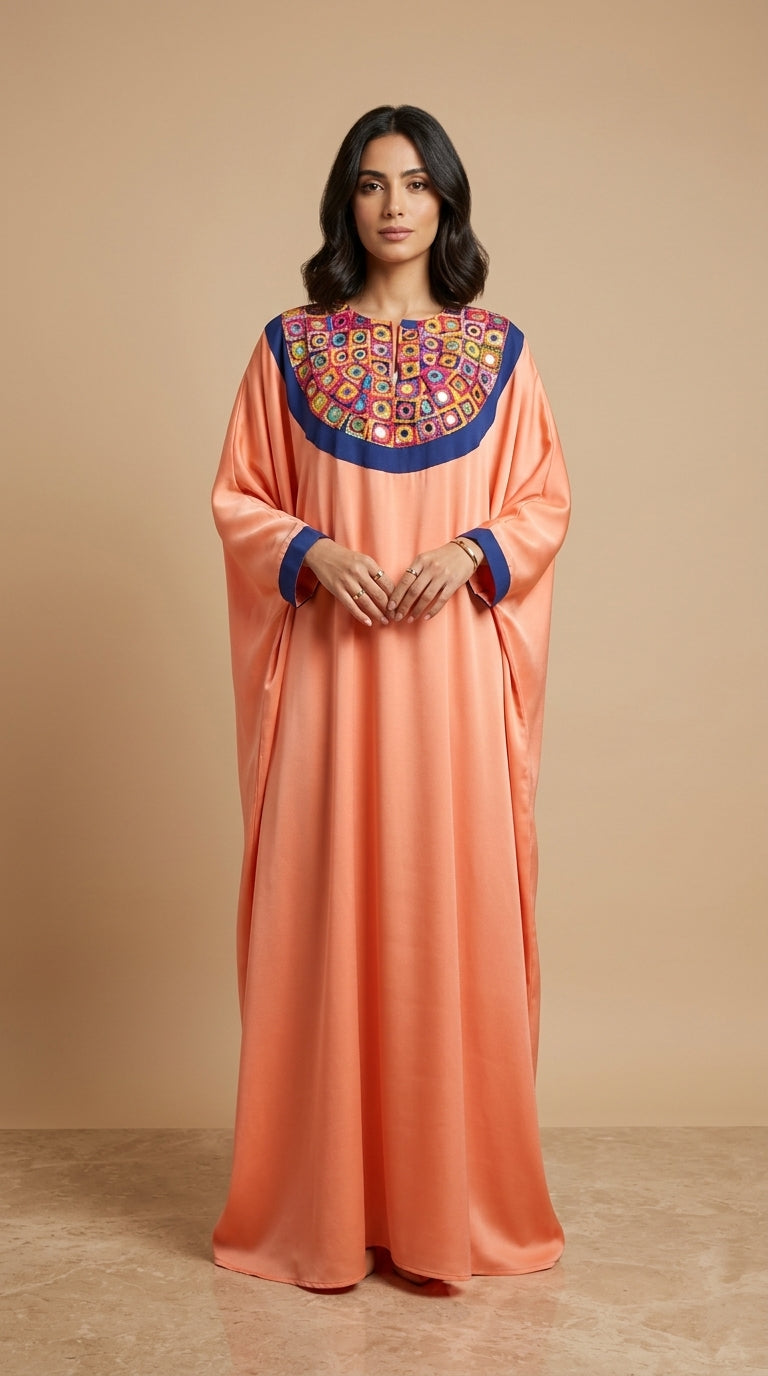 Woman wearing a peach dress with colorful embroidery on a beige background