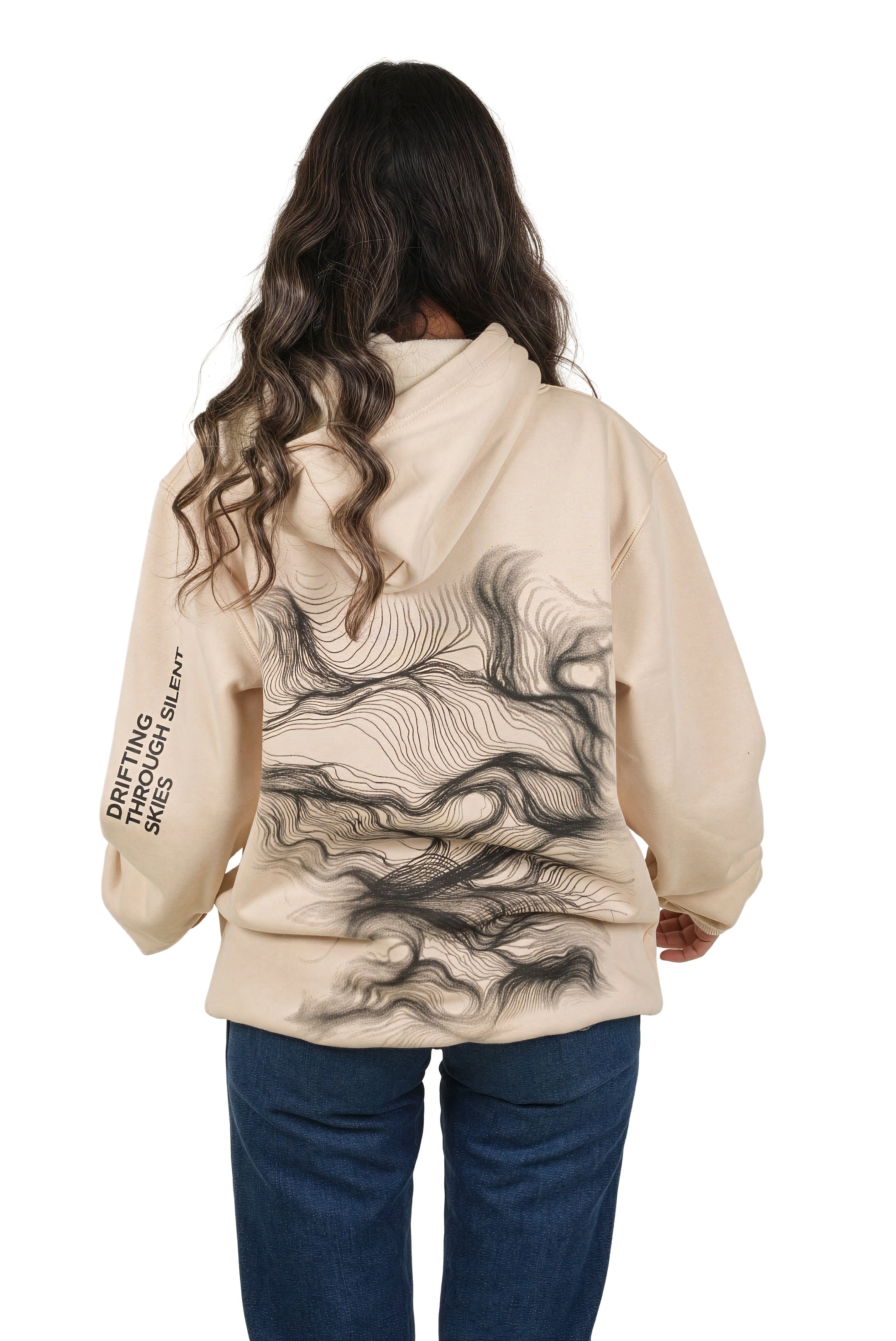 Person wearing a beige hoodie with a graphic design on the back, standing against a white background.