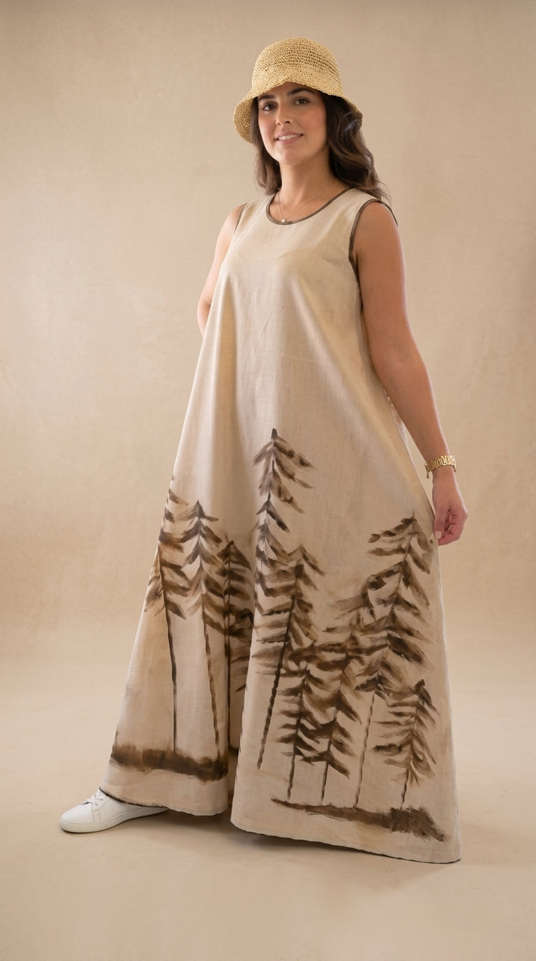 Woman wearing a beige sleeveless dress with tree pattern on a plain background