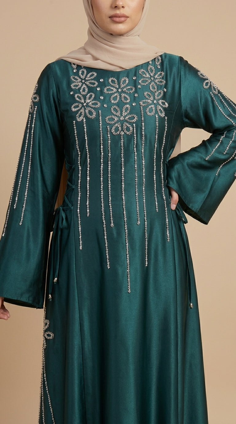 Teal dress with intricate silver embroidery on a beige background