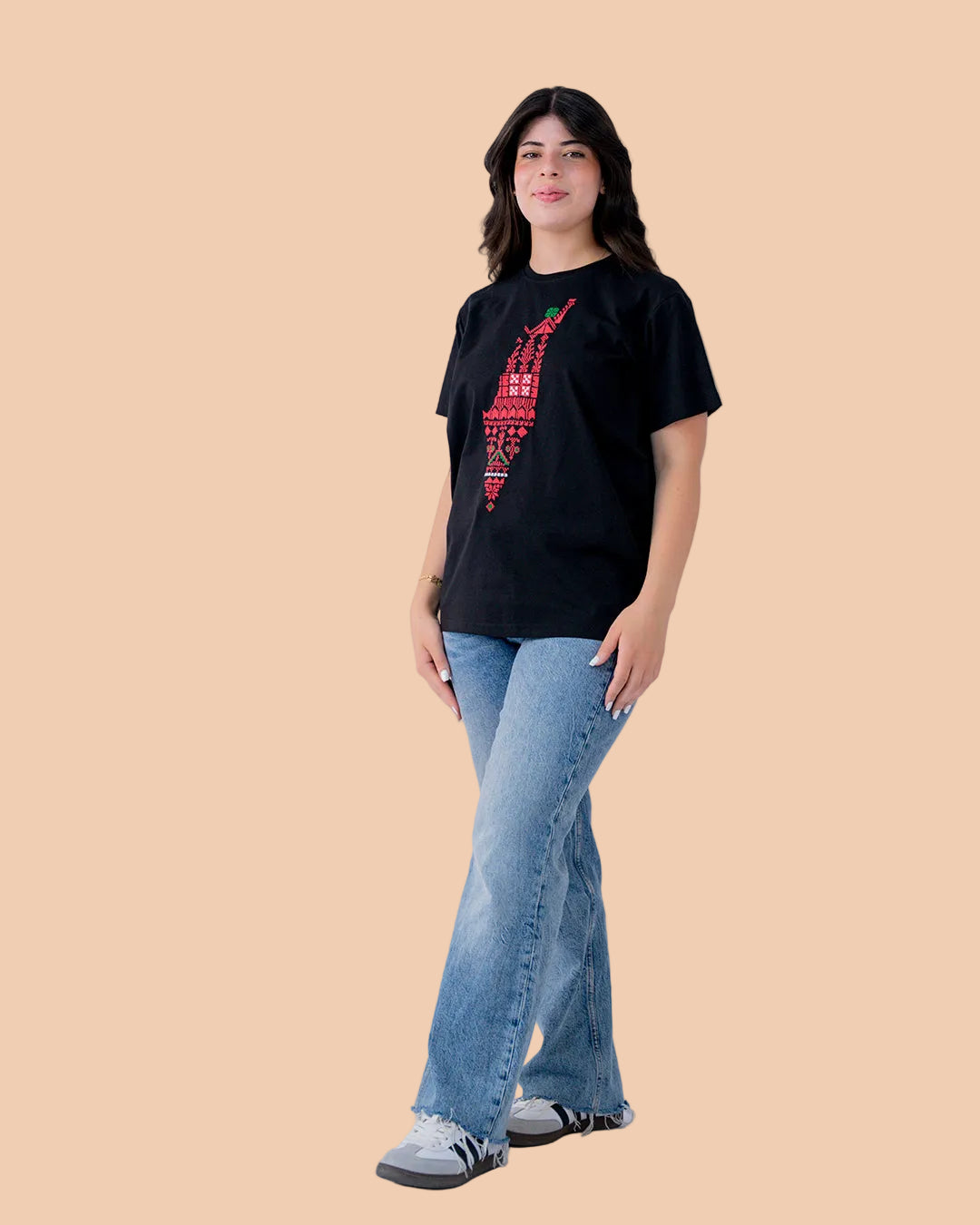 Person wearing a black t-shirt with red graphics and blue jeans on a white background