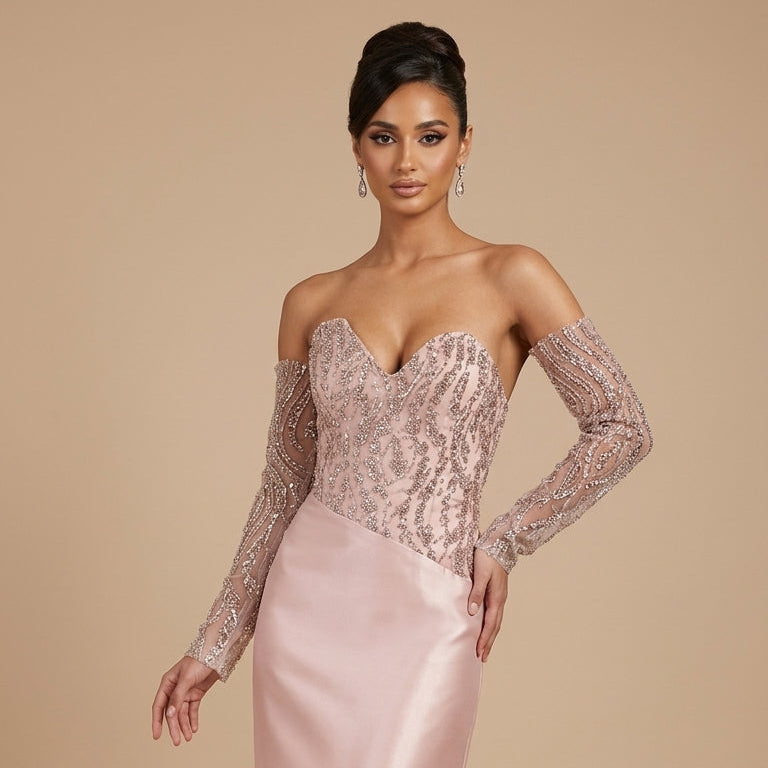 Woman wearing a pink evening gown with long sleeves on a beige background