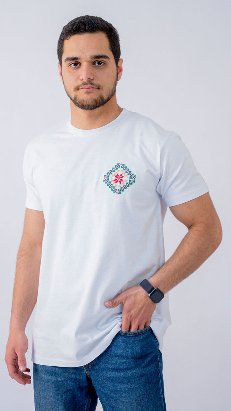 Man wearing a white t-shirt with a colorful geometric design on a plain background