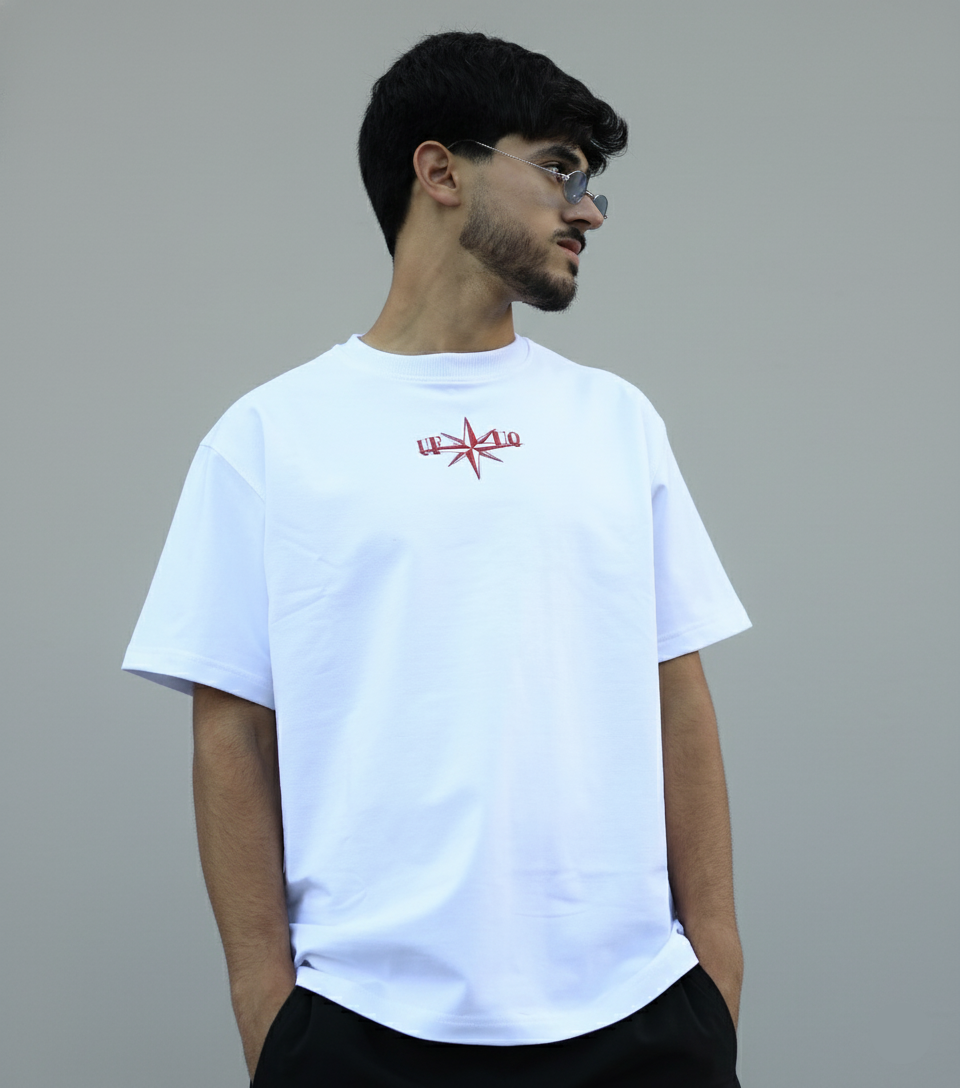Man wearing a white t-shirt with a red logo on a gray background
