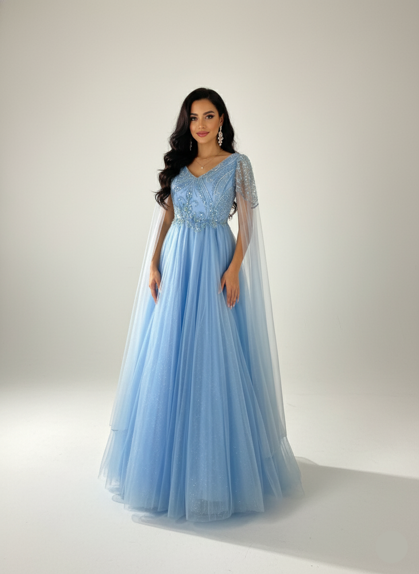 Woman wearing a light blue evening gown with a sheer overlay against a white background