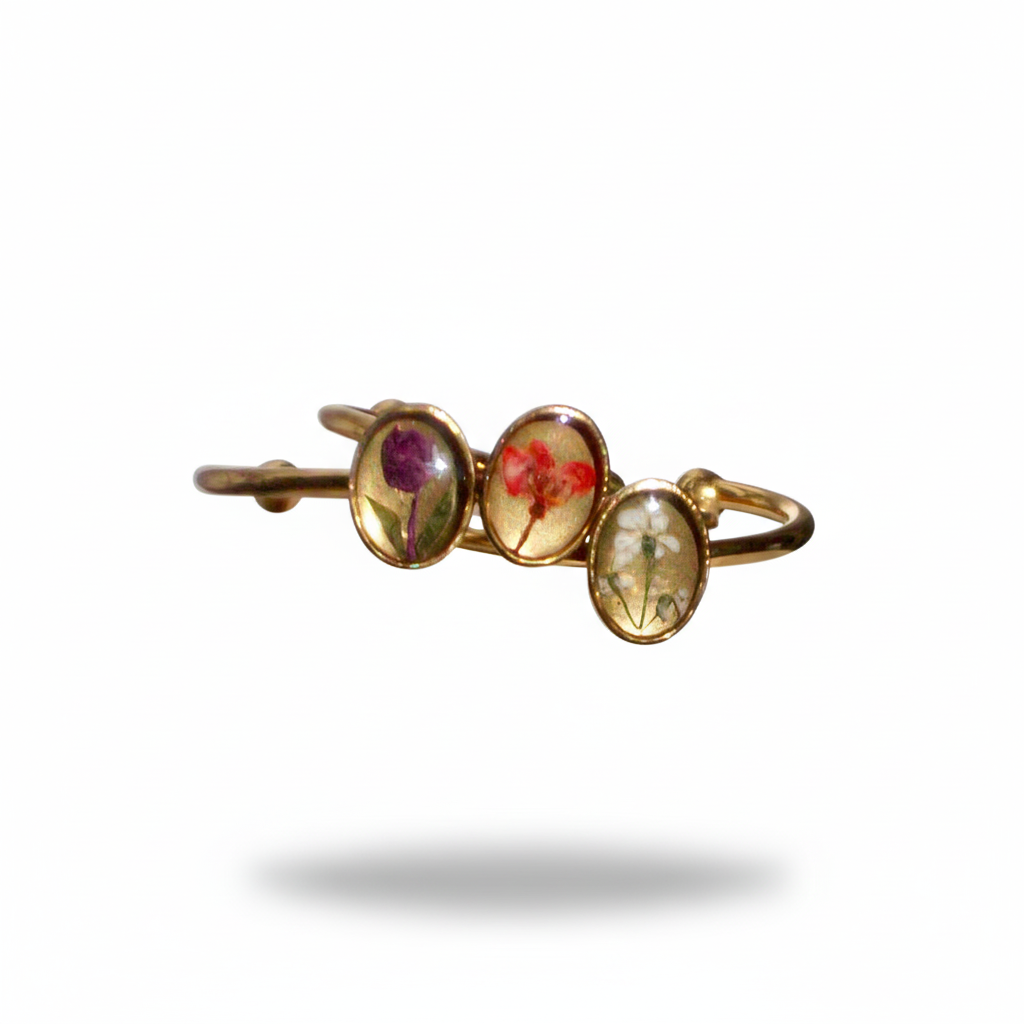 Gold ring with three oval gemstones on a white background