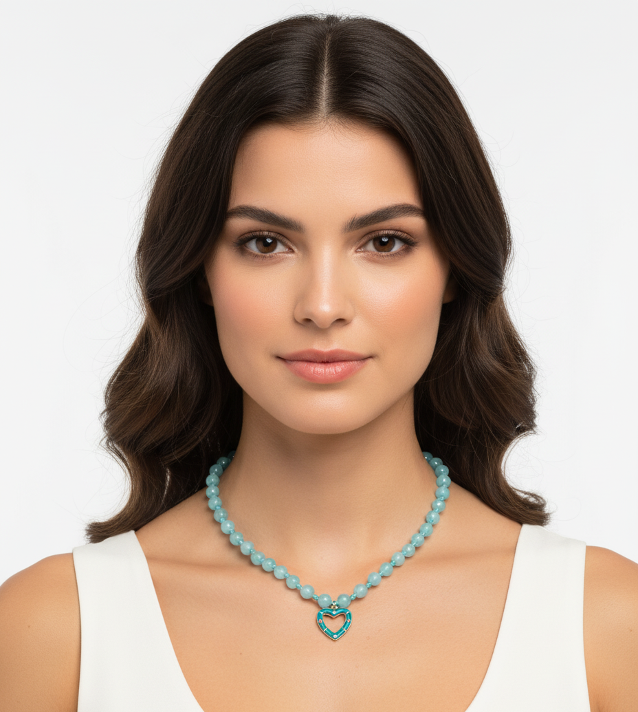 Woman wearing a turquoise necklace with a heart pendant on a white background