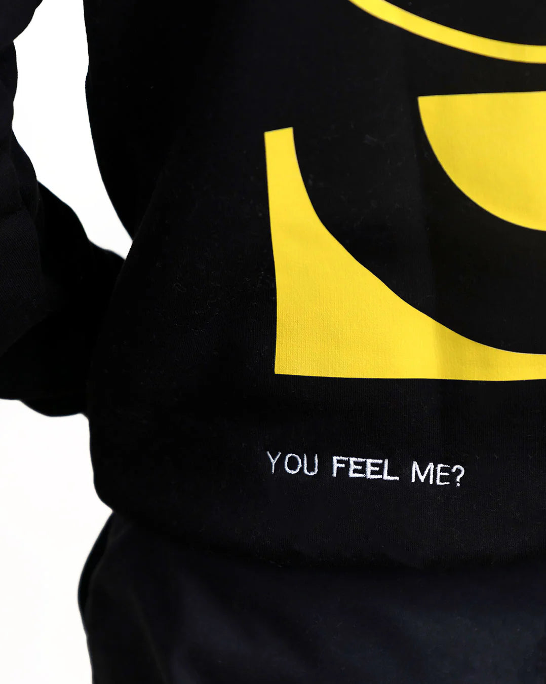Black hoodie with yellow graphic and text 'YOU FEEL ME?' on a white background