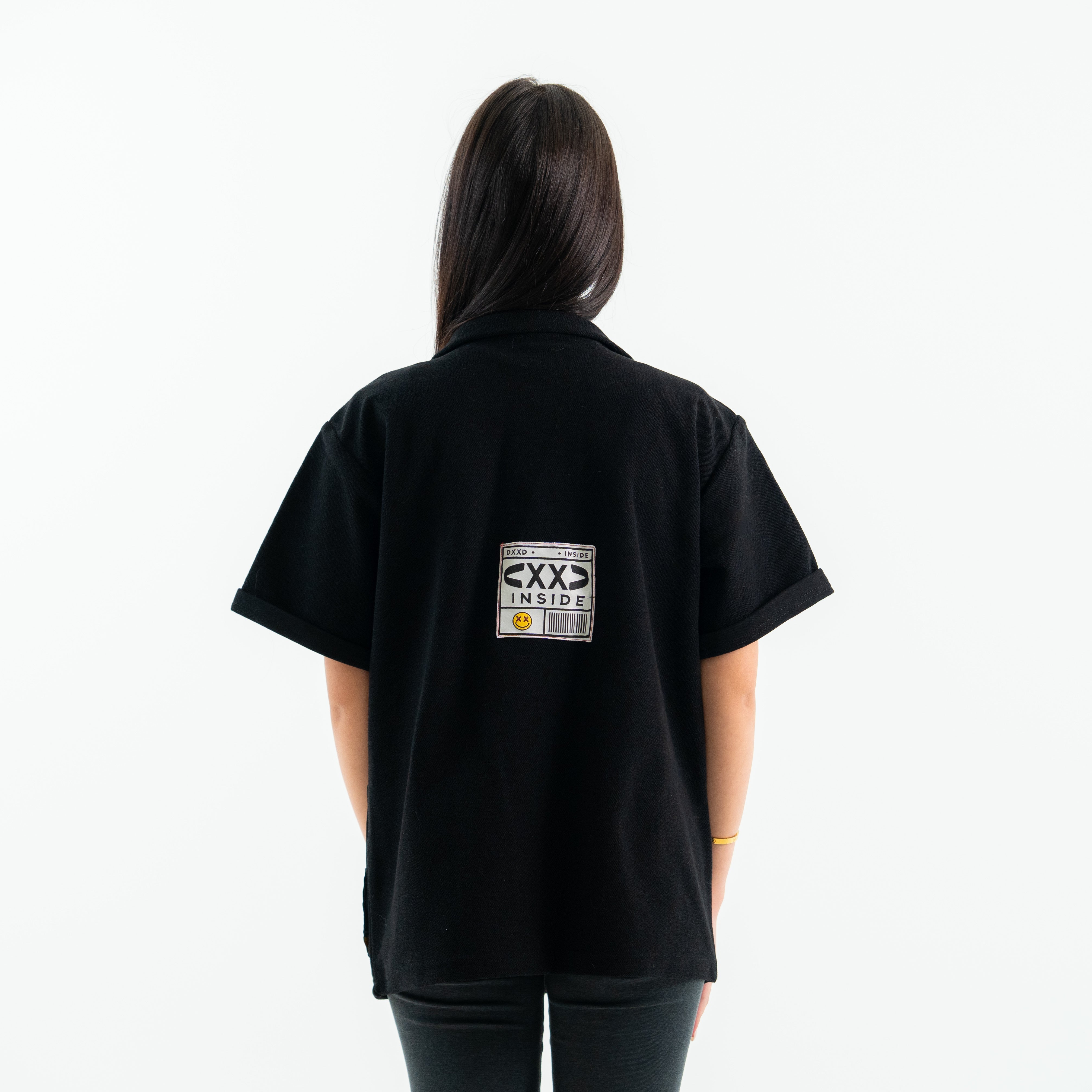 Person wearing a black t-shirt with a graphic on the back against a white background