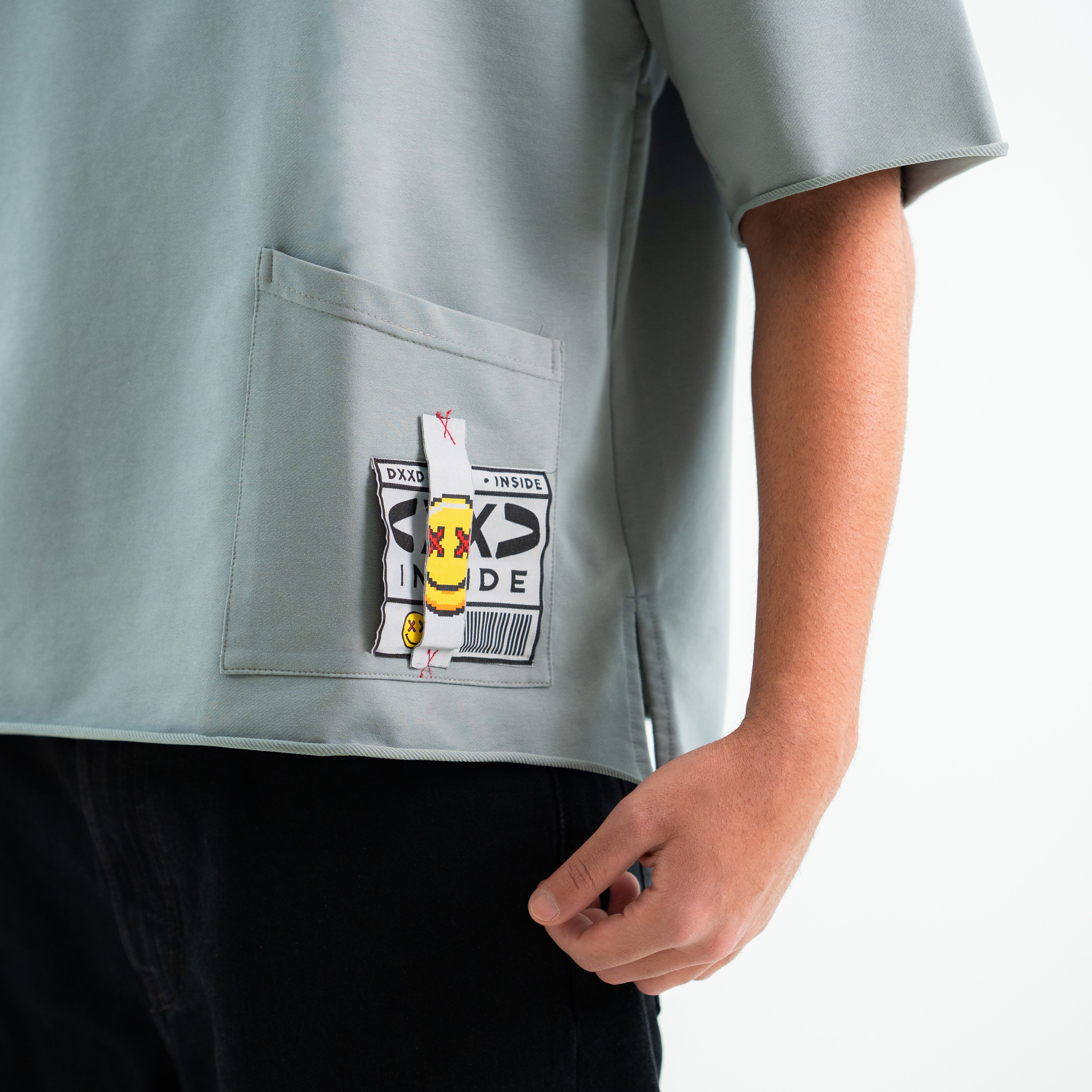 Gray shirt with a patch on the chest against a white background